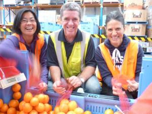 Tetra Pak Oceania managing director Noel Ayre helps Foodbank volunteers pack fresh food for Australians in need.